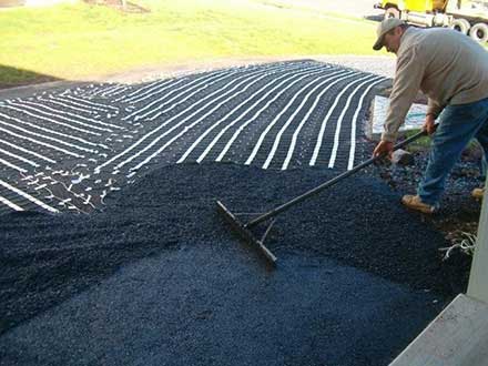 Retrofitting a driveway with radiant heat by applying asphalt over heat cable.